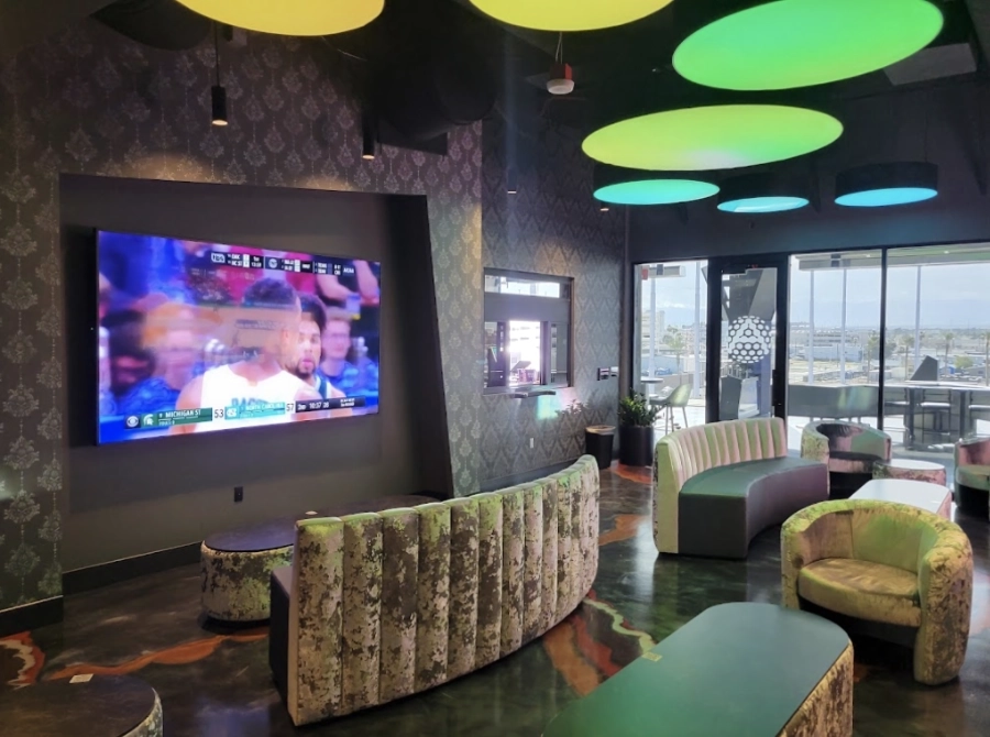 Experiential lighting with color-changing ceiling panels enhancing mood and atmosphere in an entertainment venue