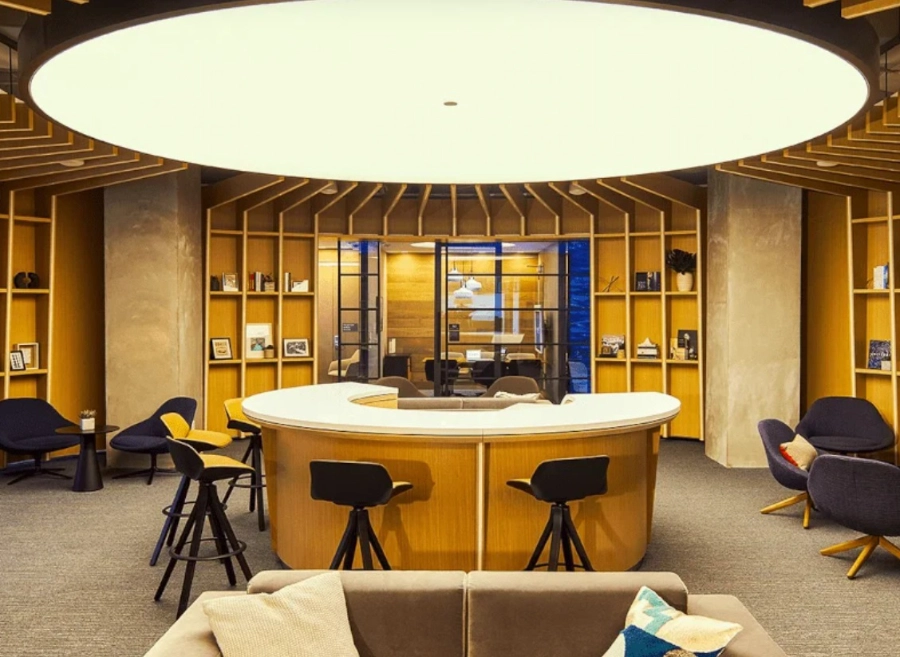 Human-centric lighting in a commercial lounge featuring a large circular architectural luminaire and warm ambient illumination