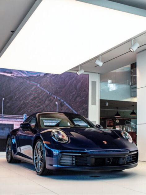 A LumiCloud™ Carra above a Porsche at the Porsche Palm Springs location