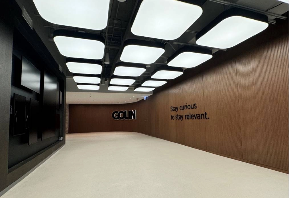 Modern corporate hallway at Golin in Chicago MART featuring wood-paneled walls and a grid of square ceiling light fixtures.